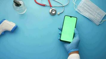 Top view of hand in latex gloves holding smart phone on clinic table video