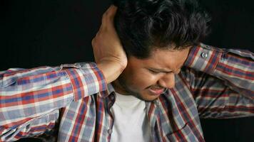 junger Mann mit Ohrenschmerzen, der sein schmerzendes Ohr berührt, isoliert auf schwarz video
