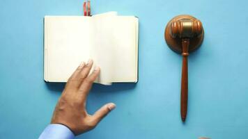 Person's hand striking the gavel on blue background video