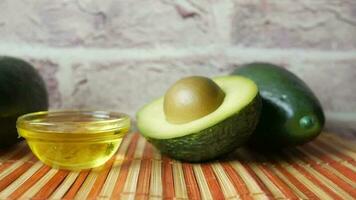 oil and slice of avocado on wooden table video