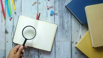 open book and magnifying glass on table video