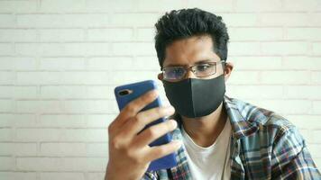 sick man in surgical face mask using smart phone, selective focus video