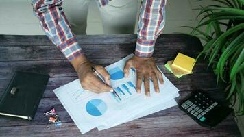 man hand with pen analyzing bar chart on paper video