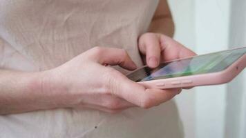 Woman hand holding cell phone touch screen typing scroll page using app. Smartphone mobile phone device in hands. Internet news content apps cellphone addiction concept video