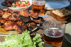 Summer picnic with barbecue, vegetables and beer photo