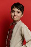 Handsome Caucasian teen boy dressed in traditional ethnic Ukrainian embroidered linen shirt, smiling looking at camera photo