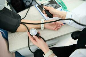 Top view gynecological nurse checking blood pressure of a pregnant woman, to prevent the pregnancy induced hypertension photo