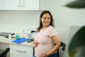 el embarazo 3d trimestre. encantador embarazada mujer visitando hembra médico obstetra para regular médico chequeo. foto