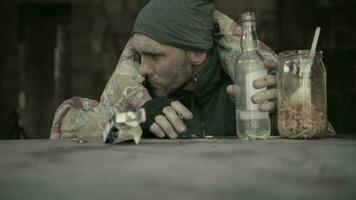 Vagabundo alcohólico Bebiendo otro botella de oso y de fumar cigarrillo dentro abandonado casa. social cuestiones tema. video