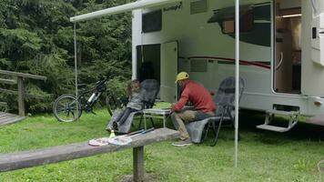 Summer Time Family Time. Father and Daughter Relaxing on the Camping in Front of Their Motorhome RV Camper Van. video