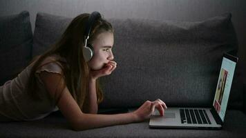 Teenage Girl Laying on a Sofa in Front of Her Laptop video