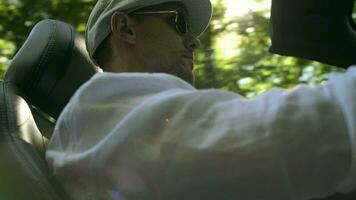 caucasiano homens dentro dele 30s desfrutando conversível carro dirigir durante quente verão dia. video