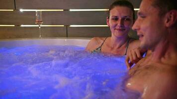 caucasien couple profiter leur Nouveau jardin spa avec hydromassage pendant en retard soir heures. video