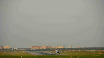 Passenger jetliner fly over and approach landing field, wide angle shot from end of runway. Air transportation concept video