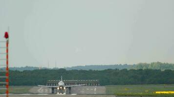 Passenger jet airplane landing at Dusseldorf airport. Long shot, the aircraft braking video