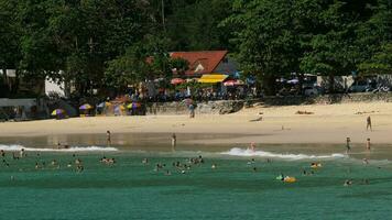 People relax on beach. Beach crowded with visitors. Hai Narn beach, one of the most popular beaches among tourists in Phuket. video