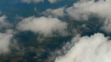 Top view of the city and fluffy white clouds. First person view from the porthole. To fly by plane. Cinematic shot in flight from the window video