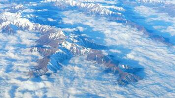 mooi visie door vliegtuig venster, vliegtuig vliegend bovenstaand de bergen met wolken. China grondgebied. video