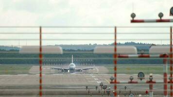 lange Schuss, unbekannt Flugzeug auf das Runway verlangsamt Nieder nach Landung, Vorderseite Aussicht video