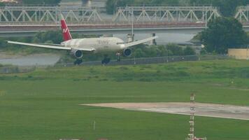 sochi, ryssland augusti 03, 2022 - bred kropp plan boeing 777 av nordvind flygbolag landning på sochi flygplats. flygplan på de bakgrund av de stad. turism och resa begrepp video