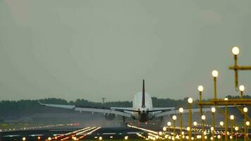 Commercial airplane landing, touching down and braking with smoke. Landing lights illuminate the runway. Cinematic footage of aircraft flight arrival video