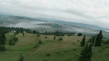 maneggevole volo nel il mattina nebbia al di sopra di un' montagna villaggio su fpv fuco video