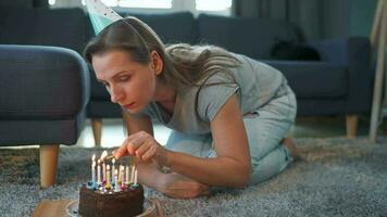 mujer Encendiendo velas en cumpleaños pastel, celebrando cumpleaños a hogar video