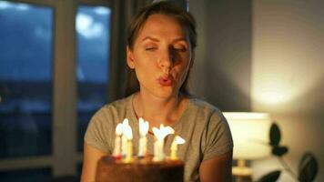 Lycklig upphetsad kvinna framställning omhuldade önskar och blåser ljus på Semester kaka, fira födelsedag på Hem, långsam rörelse video