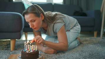 Woman lighting candles on birthday cake, celebrating birthday at home video