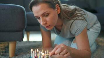 Woman lighting candles on birthday cake, celebrating birthday at home video