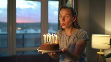 glücklich aufgeregt Frau Herstellung geschätzt Wunsch und weht Kerzen auf Urlaub Kuchen, feiern Geburtstag beim heim, schleppend Bewegung video