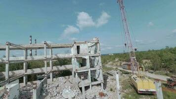 fpv zangão moscas suavemente entre abandonado industrial edifícios e por aí a escavadora video