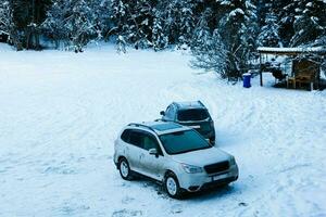 Two dirty cars covered with snow. Driving in winter season is danger. photo