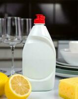 detergente, limón, esponja y limpiar platos en el mesa en el cocina. limpieza Servicio concepto. de cerca. selectivo enfocar. foto