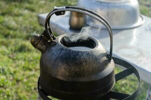 Kettle with water on the stove outside. Boiling water in difficult times. photo