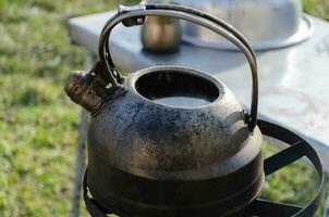 Kettle with water on the stove outside. Boiling water in difficult times. photo