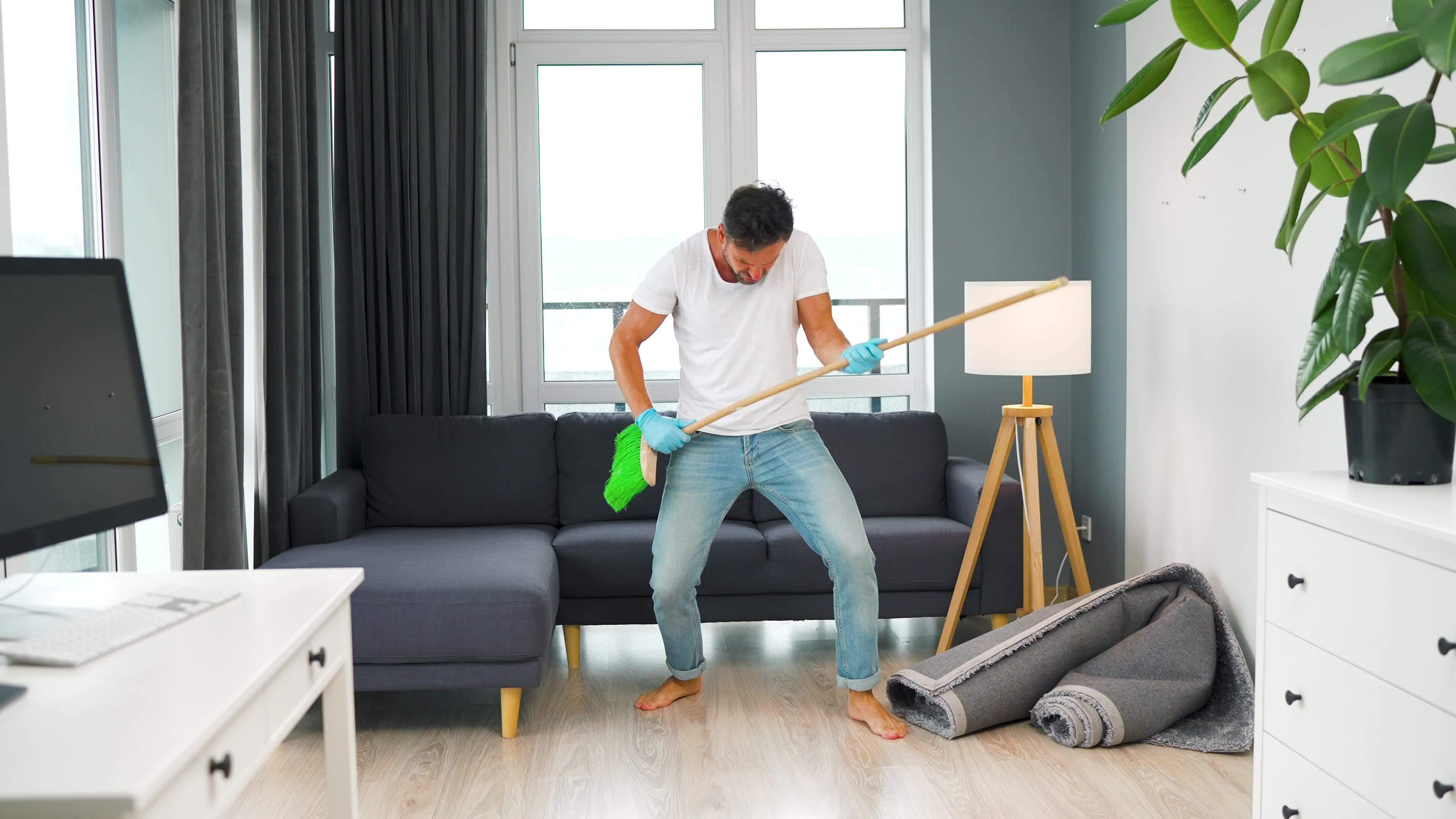 Man in headphones does the cleaning and imagines himself a rock star ...