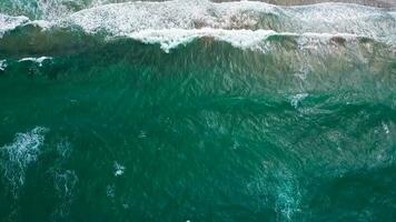 aéreo ver de el Mediterráneo costa, olas alcanzar el abandonado arenoso playa video