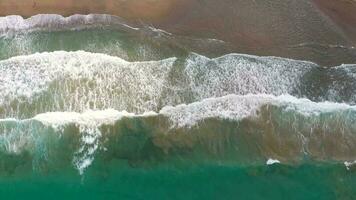 aéreo ver de el Mediterráneo costa, olas alcanzar el abandonado arenoso playa video