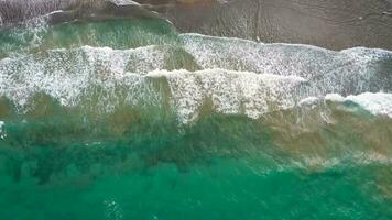 aéreo ver de el Mediterráneo costa, olas alcanzar el abandonado arenoso playa video