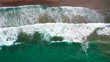 aéreo ver de el Mediterráneo costa, olas alcanzar el abandonado arenoso playa video