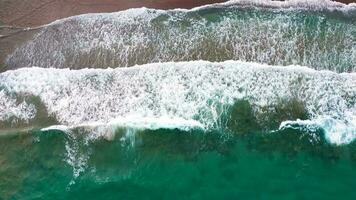 aéreo ver de el Mediterráneo costa, olas alcanzar el abandonado arenoso playa video