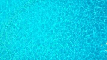 Blue water in the swimming pool with light reflections. Aerial footage video