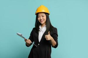 Asian woman engineer standing with thumb up and holding check list on clipboard on isolated background photo