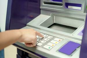 Closeup of hand entering PIN code into an ATM bank machine. photo