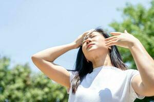 Asian woman drying sweat with a cloth in a warm summer day photo