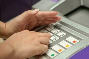 Female hand entering password on ATM machine. She hid it with her other hand for safety. photo