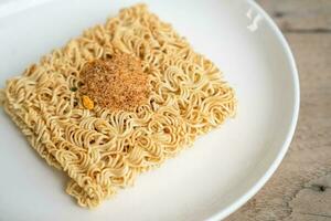 Instant noodles with condiments on the plate photo