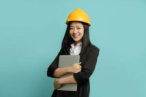 Beautiful Asian engineer wearing black suit and safety helmet, She is holding a tablet computer isolated background. photo
