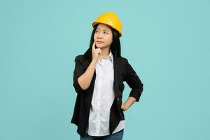 Beautiful Asian engineer in black suit and helmet She was wondering something and looked up. photo